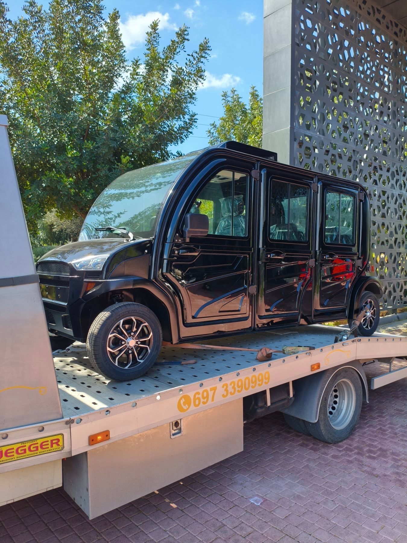 Μαύρο ηλεκτρικό όχημα δεμένο με ιμάντες στην πλατφόρμα της Instant Assistance